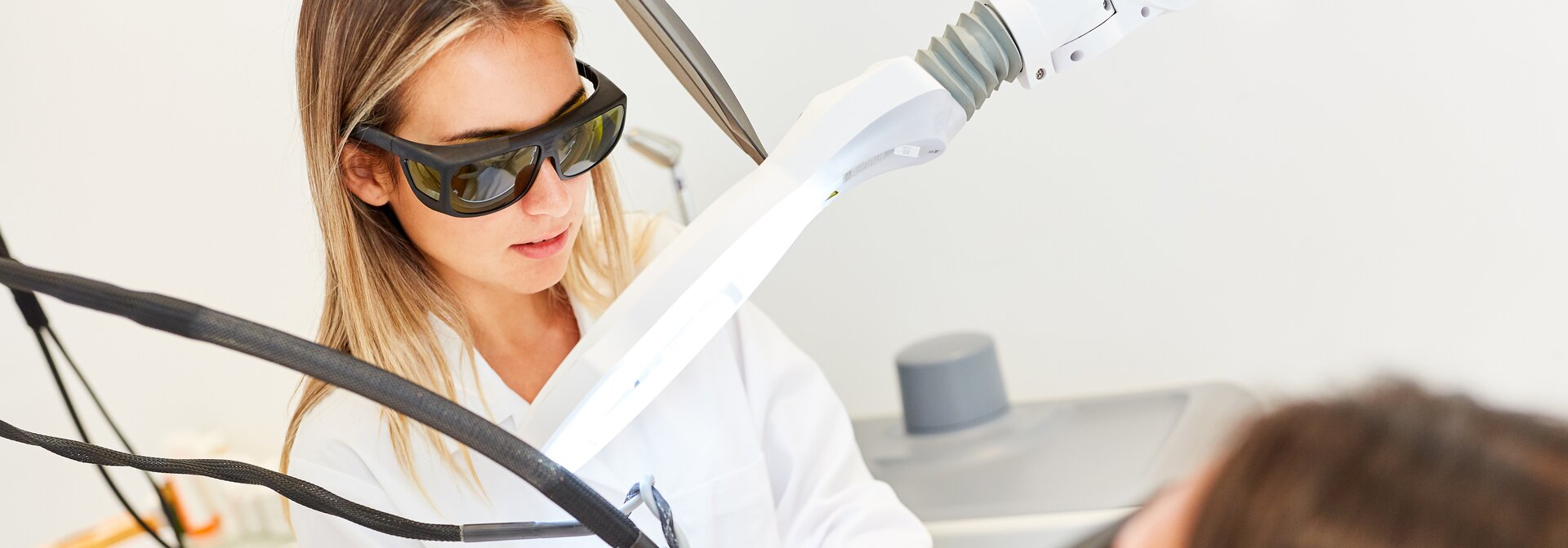 Ärztin lasert Haut einer Patientin