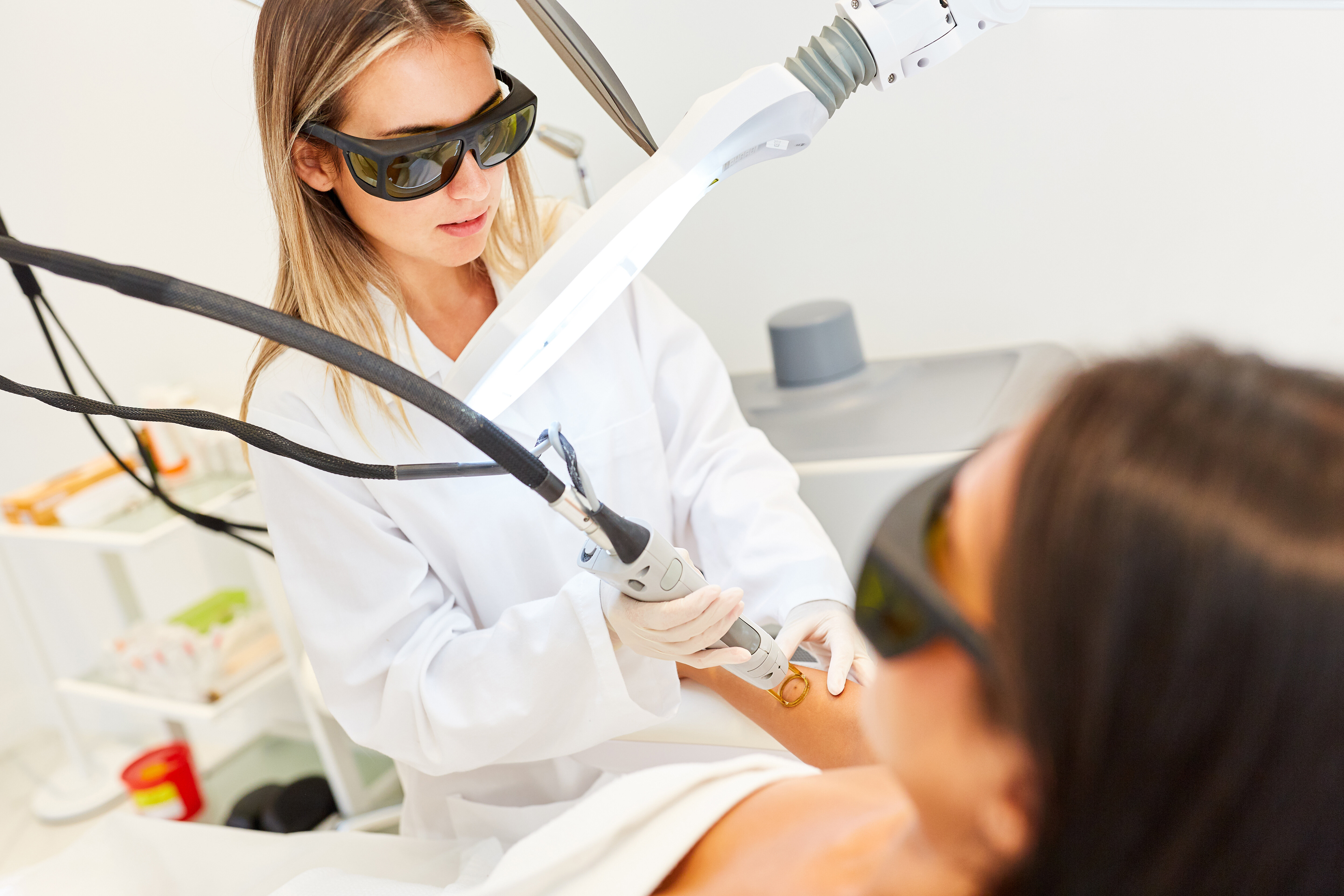 Ärztin lasert Haut einer Patientin